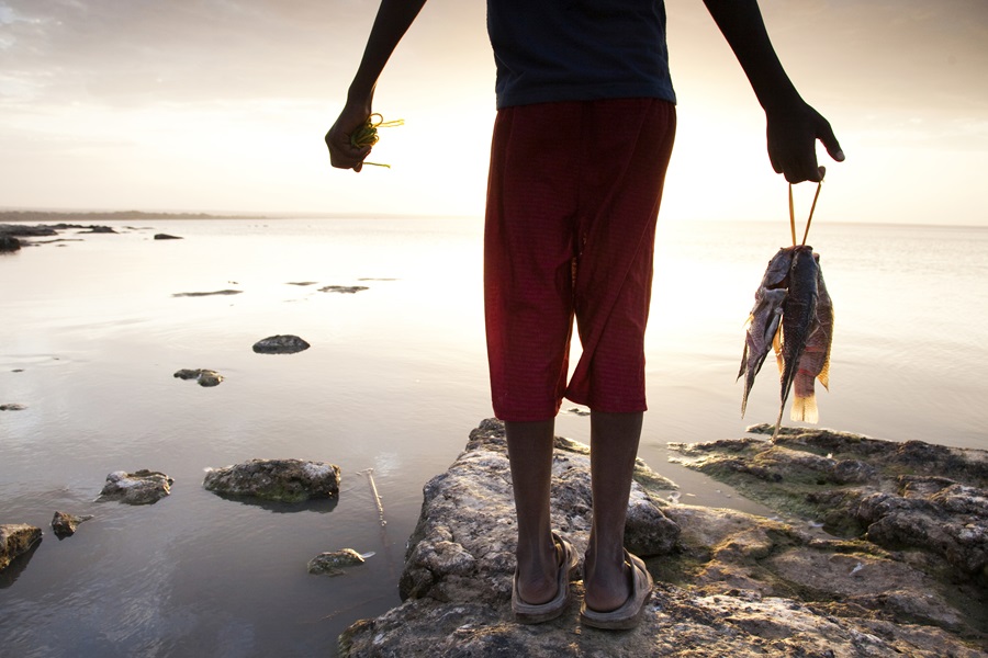 A young Ethiopian boy holds his fresh catch on the shores of Lake Langano, Ethiopia.