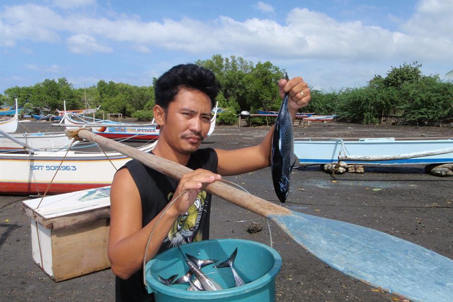 Fisherman showing daily catch in Calatagan, Verde Island Passage, Philippines.