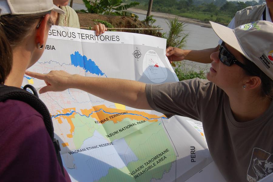 Group of people looking at a map of the Amazon rainforest in Ecuador Group of people looking at a map of the Amazon rainforest in Ecuador