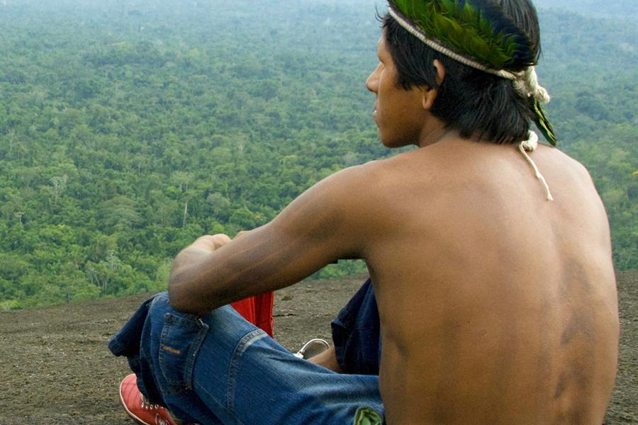 Kayapo man on top of mountain with forest. Kayapo man on top of mountain with forest.