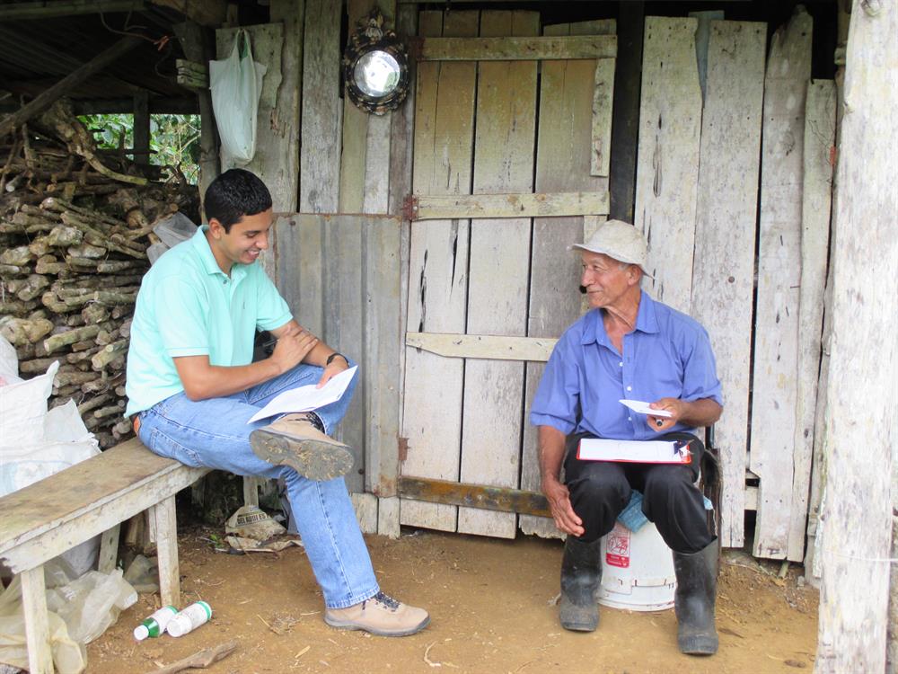 A coffee farmer answers survey questions as part of the CASCADE project.