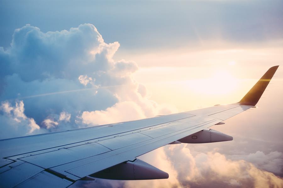 ross-parmly-25230-unsplash The wing of a jumbo jet in mid flight